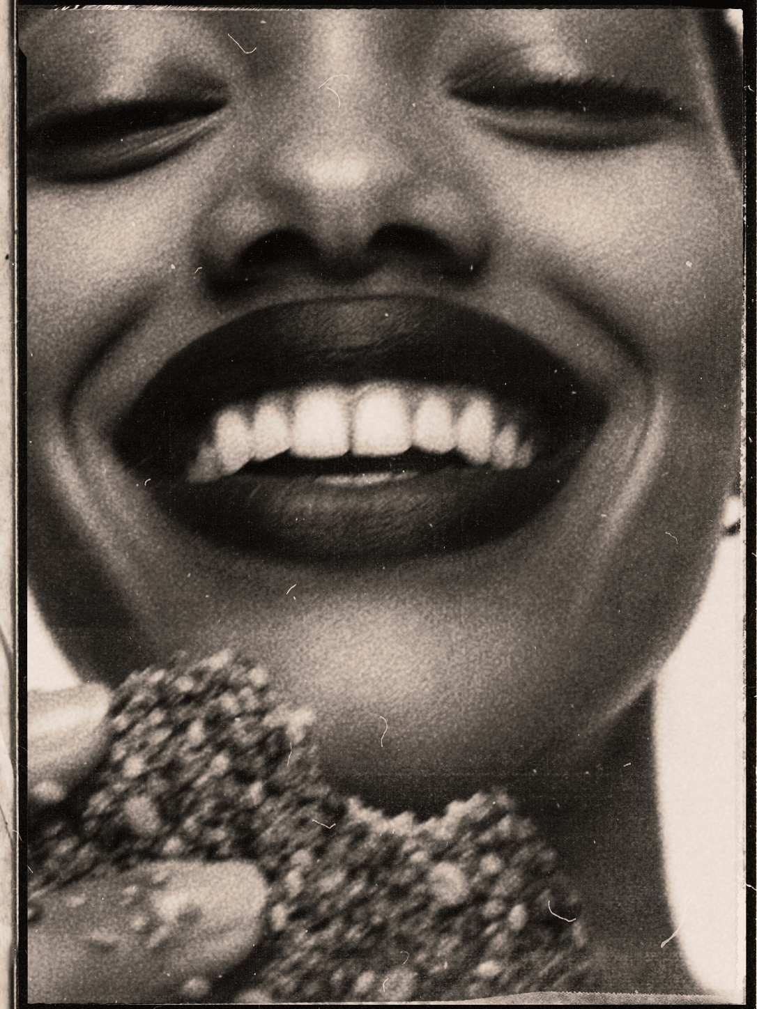 Black and white close crop of a mouth biting seed bread