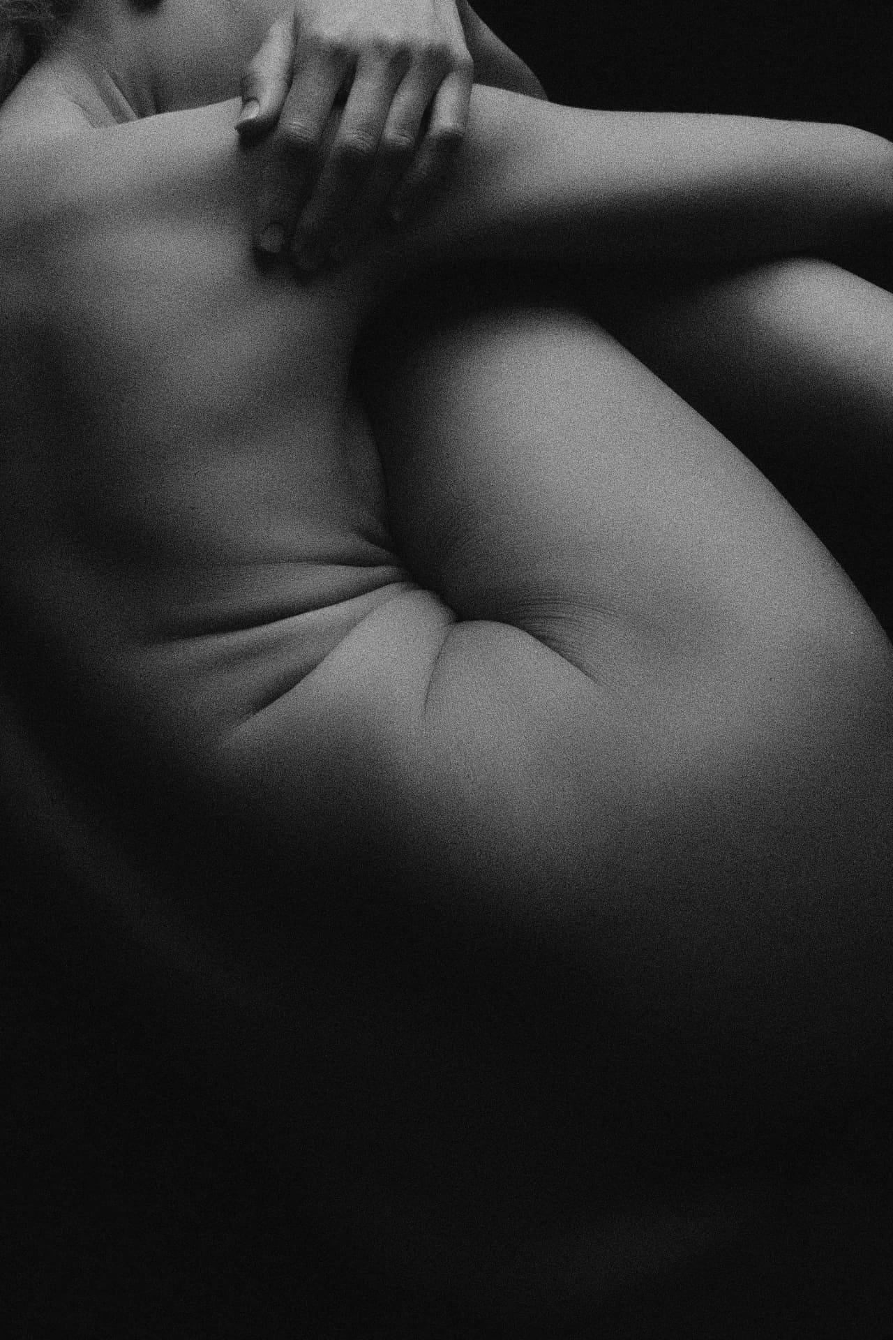Close-up of a resting body in soft black and white light